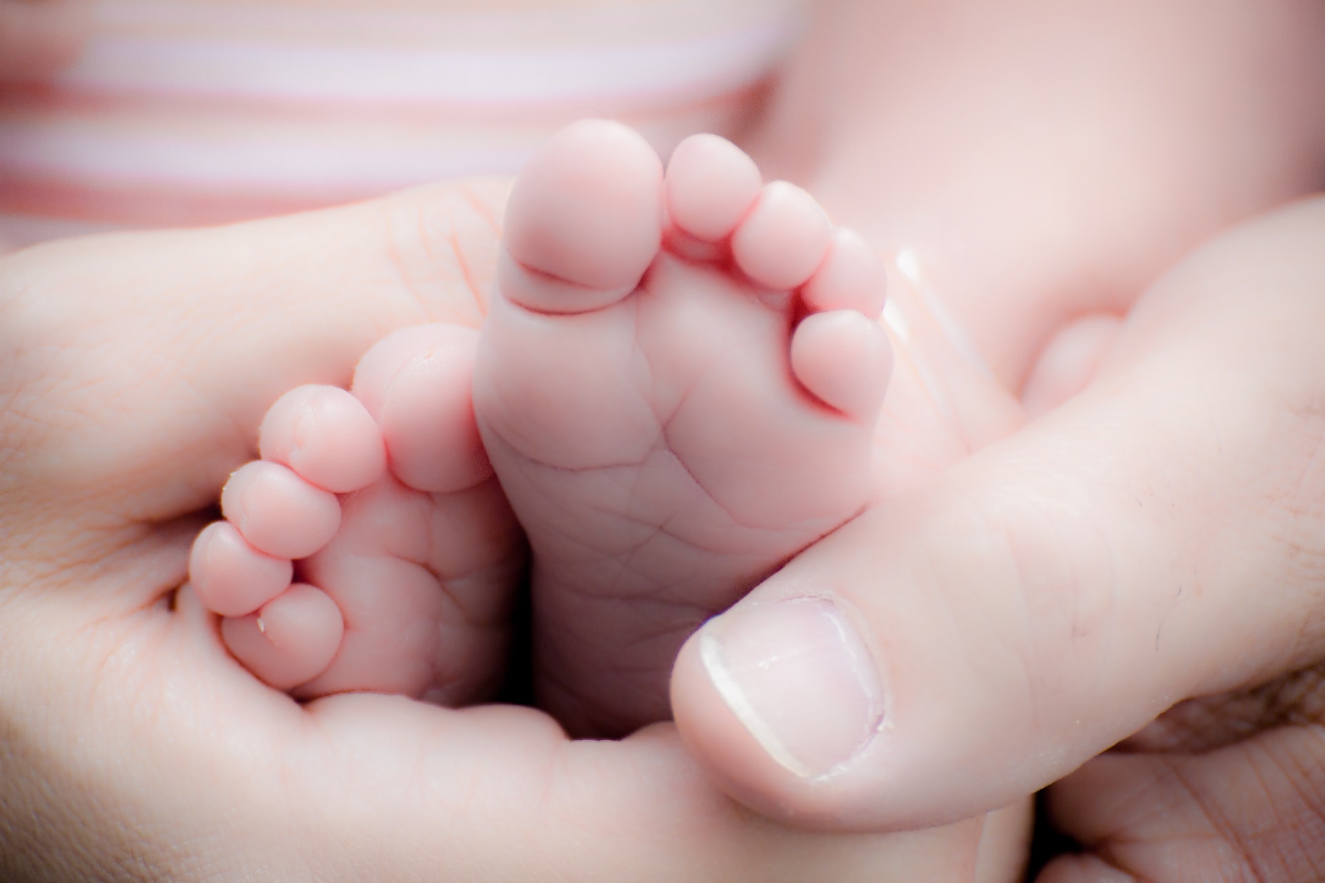 parents holding newborn baby's feet after healthy birth
