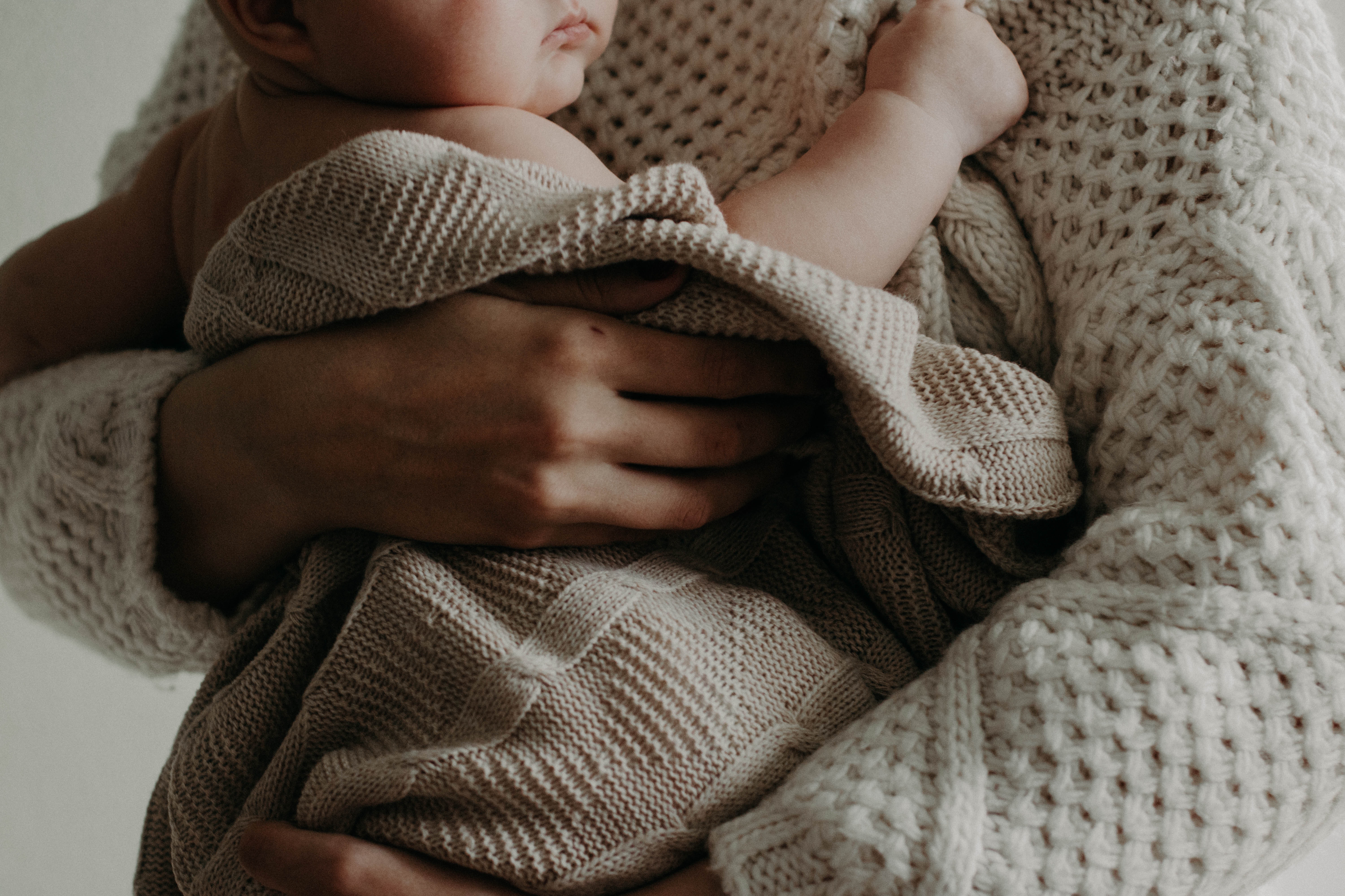 woman holding her baby in a blanket