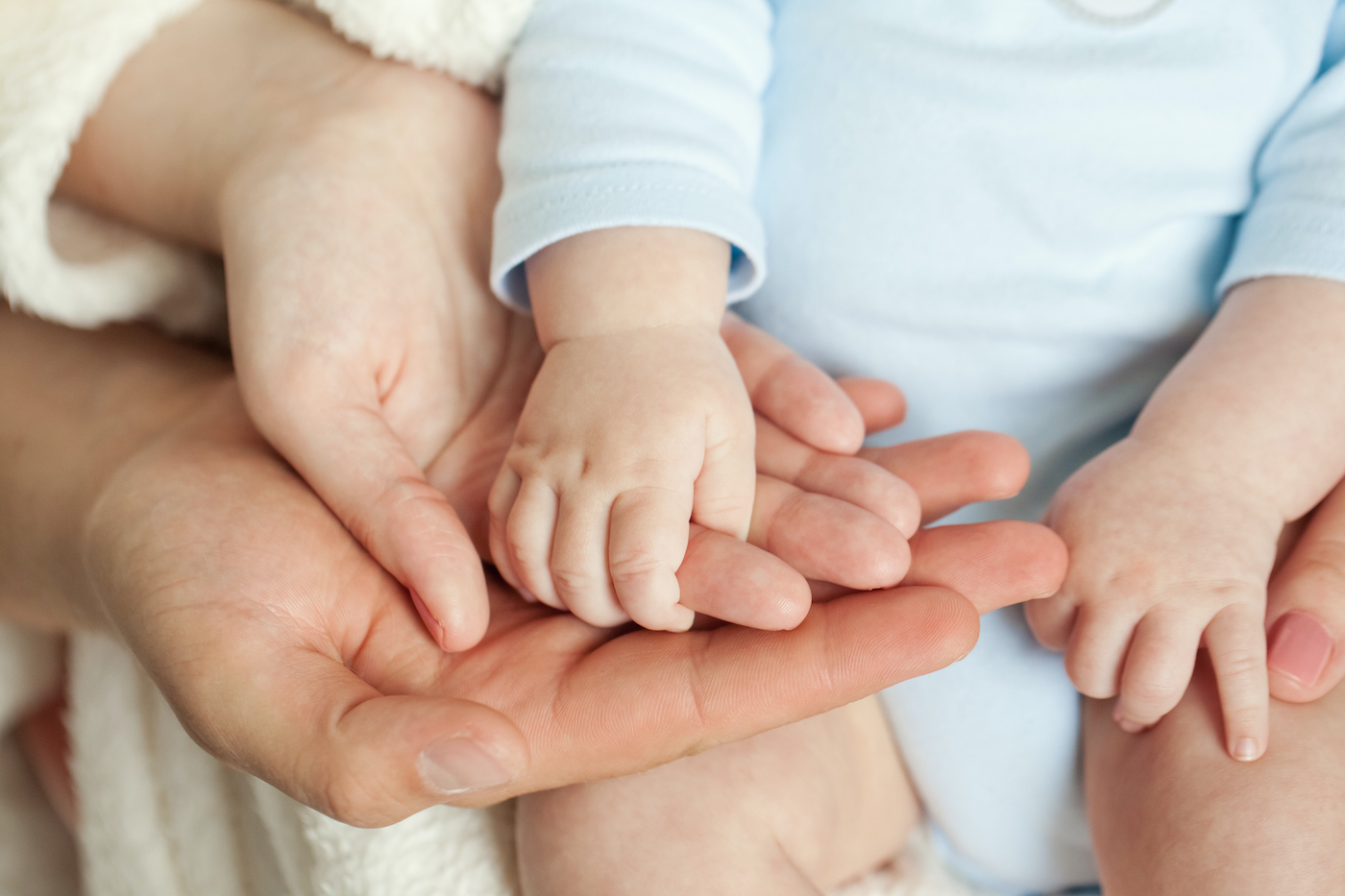 parents holding their baby's hand after fertility treatment