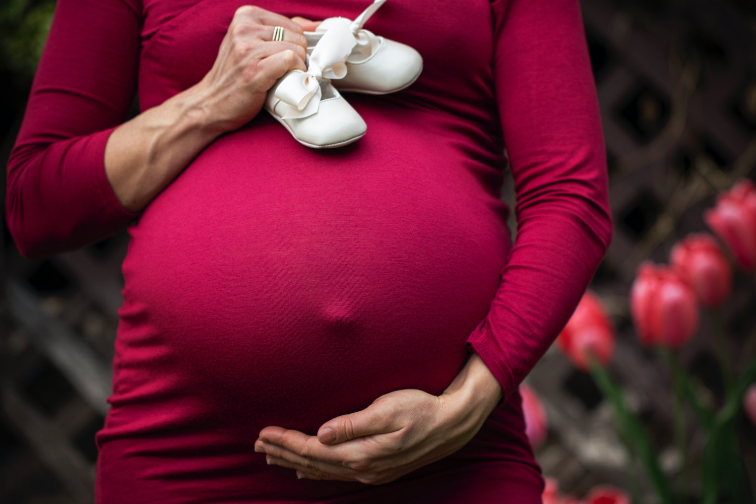 Pregnant mom holding baby shoes
