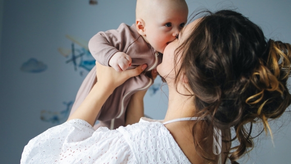 Woman lifting and kissing her baby