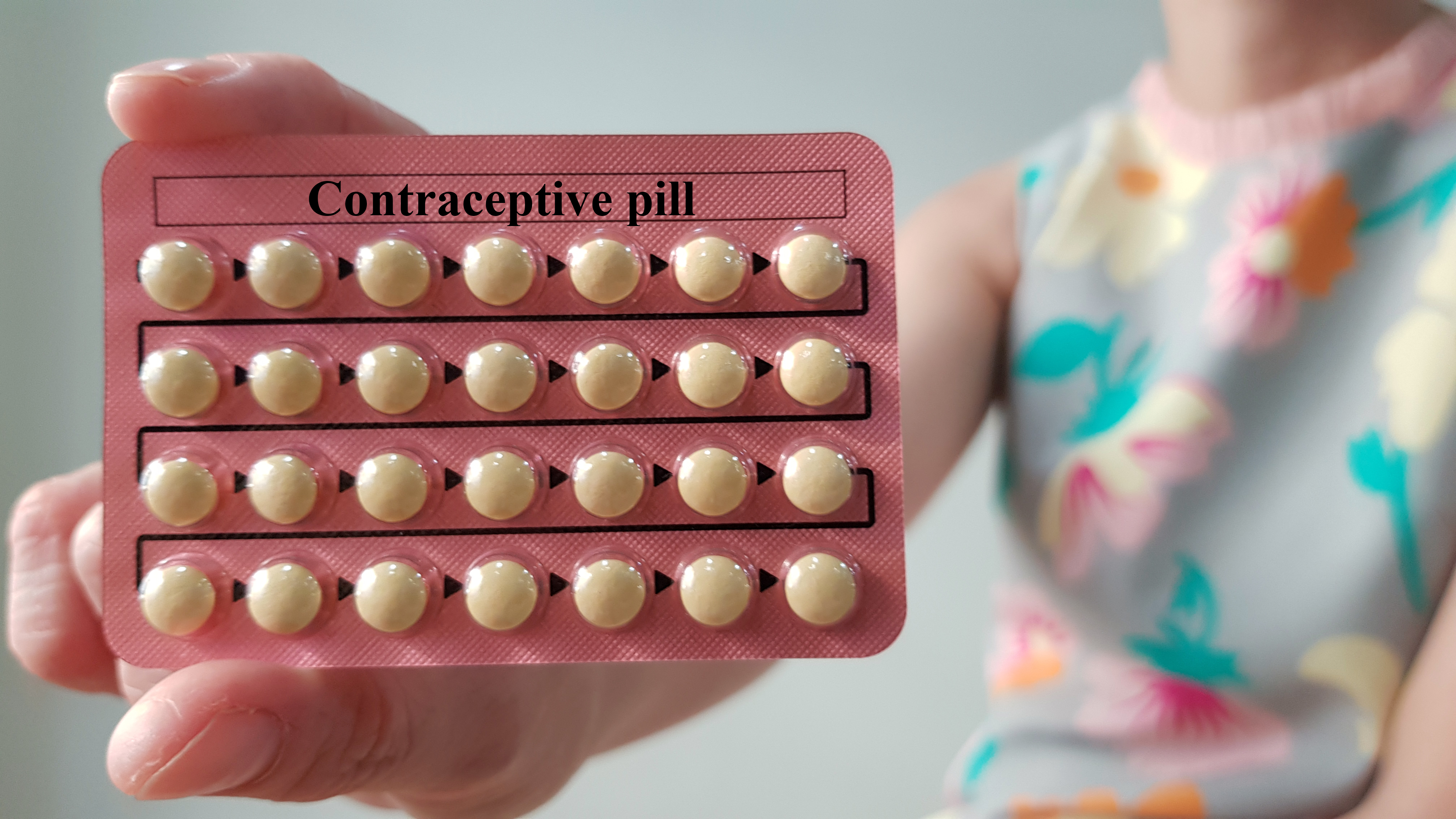 woman showing her contraceptive pill pack before considering north houston fertility treatment