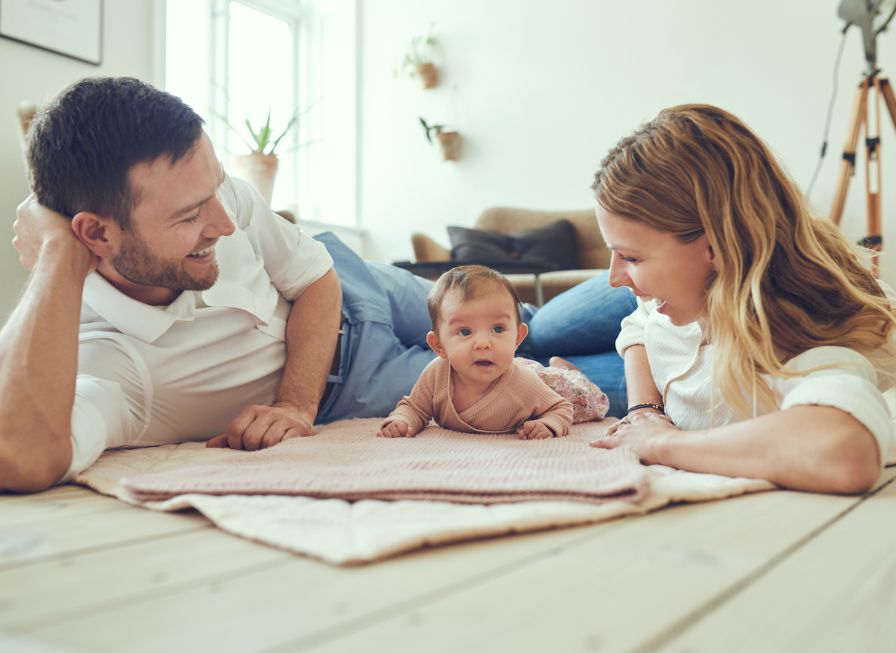 Parents laying on the floor with their north houston ivf baby