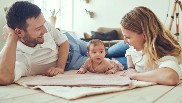Parents laying on the floor with their north houston ivf baby