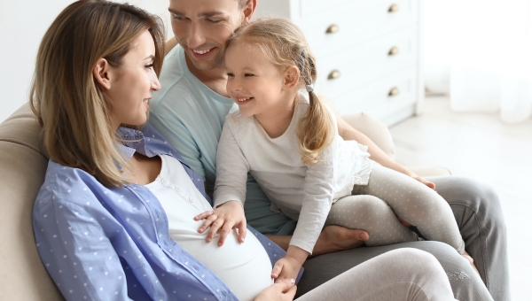 Dad with pregnant mom after IVF treatment and daughter feeling baby kick