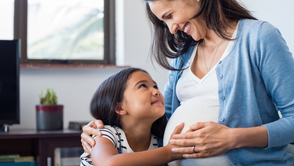 Daughter touching her mom's belly while mom is pregnant after North Houston IVF treatment