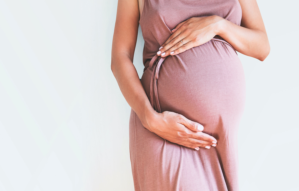 Pregnant woman holding her belly after successful IVF pregnancy