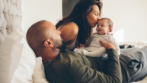 Multiracial couple playing with their IVF baby